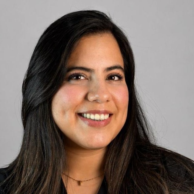 La Dra. Isabel Ruiz, sonriendo, con blusa negra