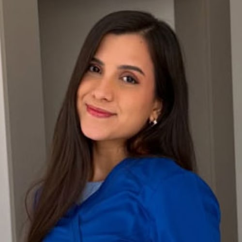 La Dra. Paola Ruiz, sonriendo, con uniforme médico azul